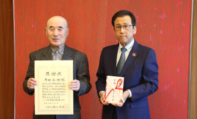 寄付を行った角田義一郎氏と秋元市長の写真