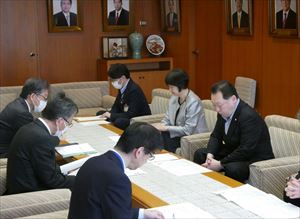 報告書の説明を受ける長内議長(右)と 村上副議長(右から2人目)