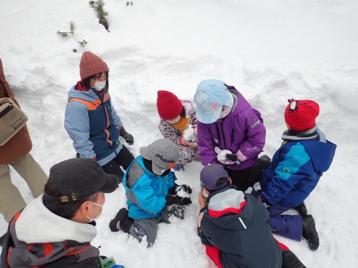 雪を高く積み上げるゲームを楽しむ子どもたち