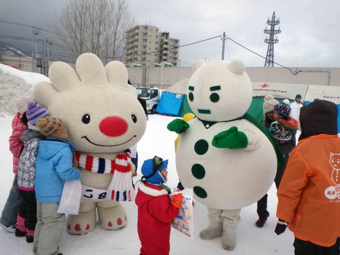 雪の祭典で、ゆきだるまんと一緒に子供と触れ合う、ていぬの様子を写した画像