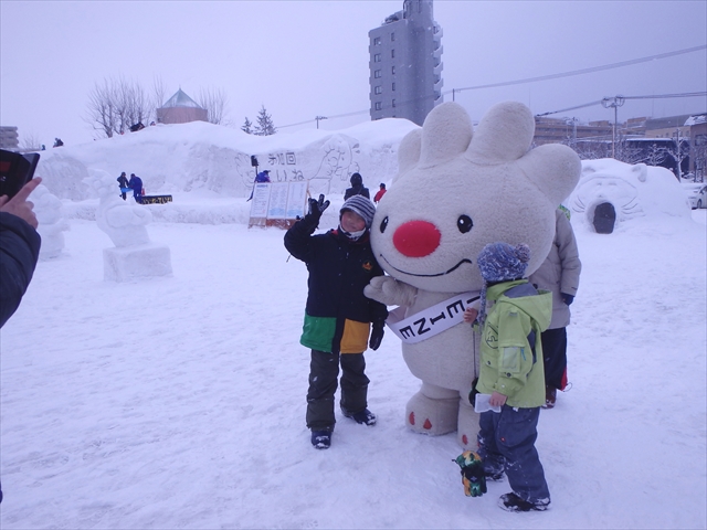 ていね雪の祭典の会場で、雪上で子供たちと記念撮影をする、ていぬの画像