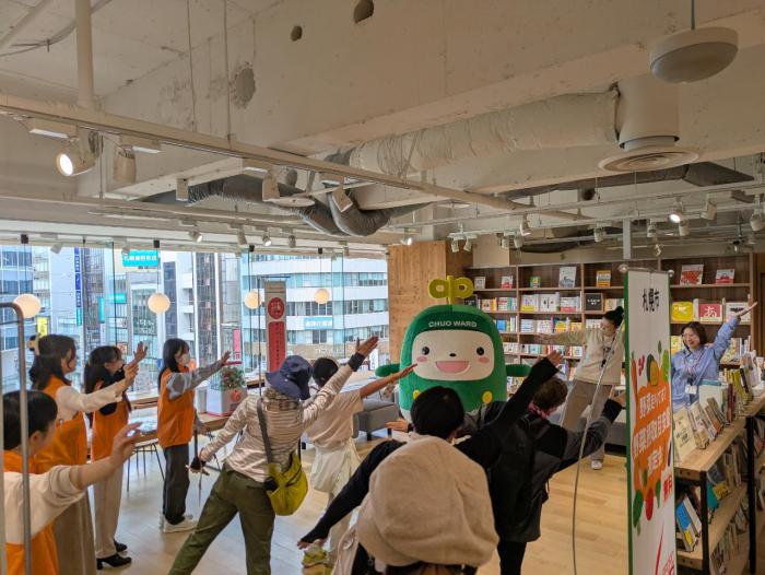 中ウォークんと参加者がイベント会場で体操している画像