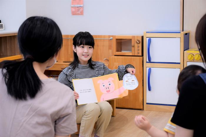 子育てサロンの利用者に絵本を読み聞かせる縄さん