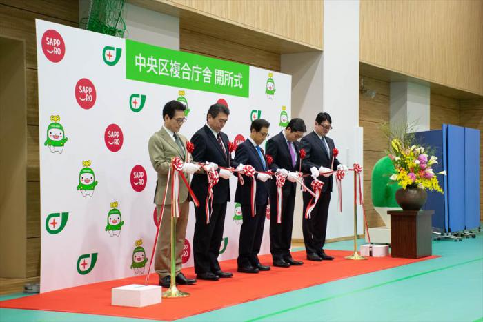 テープカットの様子（左から加藤会長、吉田社長、秋元市長、飯島議長、赤尾社長）