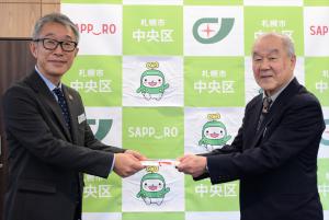 寄付金贈呈（左：久道区長、右：狩谷会長）