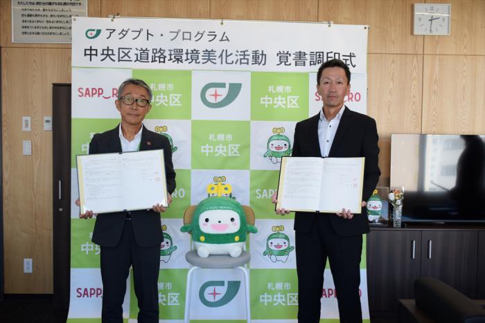 覚書締結の記念撮影（久道区長（左）、八並代表取締役社長（右））
