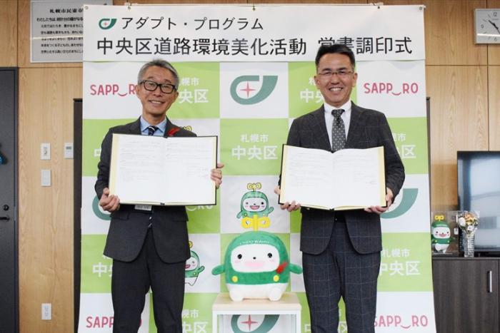 覚書締結の記念撮影（久道区長（左）、宮西支社長（右））