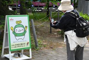大通公園内に設置されたパネルを撮影する参加者