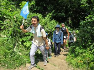 先頭を歩くスキンヘッドカメラの岡本さんと後ろに続く参加者