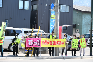 春の全国交通安全運動実施中の旗を掲げる地域住民