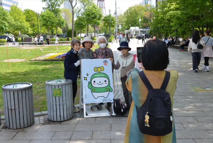大通公園内に設置されたパネルと記念撮影する参加者1