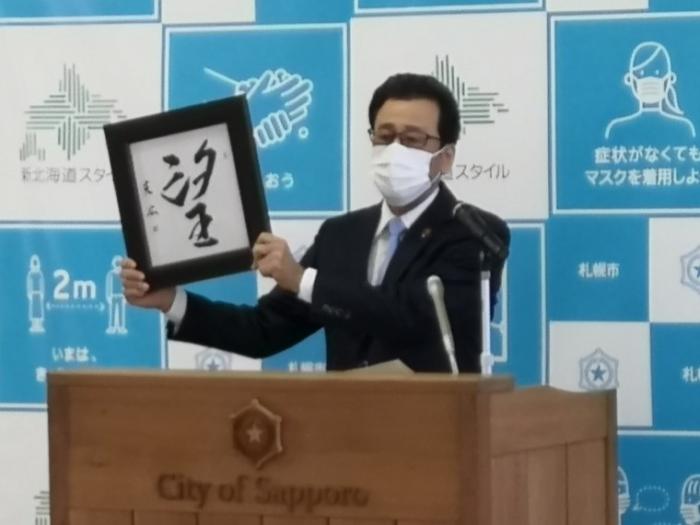 「望」の漢字を掲げる秋元市長