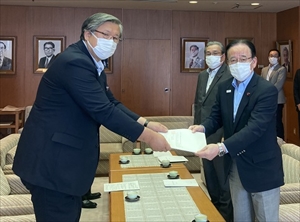 常本札幌市人事委員会委員長（左）から勧告書の手交を受ける細川議長と峯廻副議長