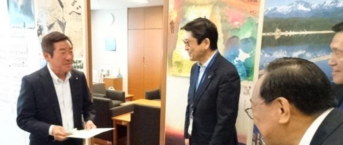 勝部賢志参議院議員（左）に要望書を渡す飯島議長（写真中央）