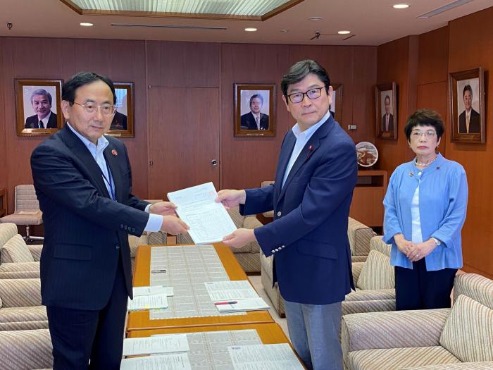 藤江代表監査委員（左）から報告書の手交を受ける飯島議長（右から2人目）としのだ副議長（右から1人目）