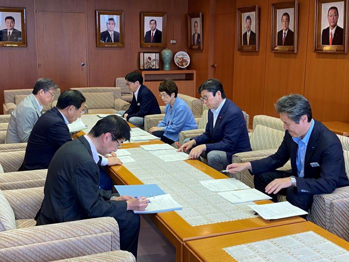 報告書の説明を受ける飯島議長（右から２人目）としのだ副議長（右から３人目）