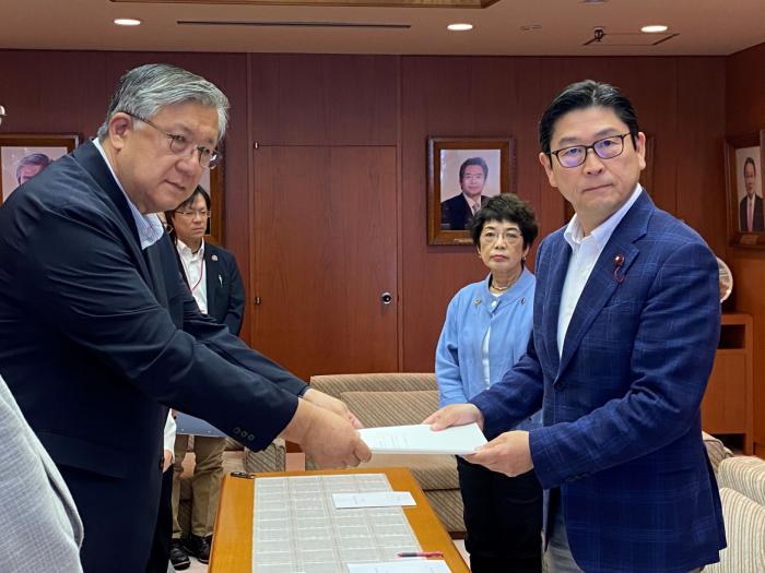 常本委員長（左）から報告書の手交を受ける飯島議長（右）としのだ副議長（右から2人目）