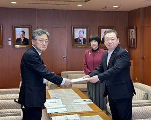 庄司代表監査委員(左)から報告書の手交を受ける長内議長(右)と村上副議長(右から2人目)