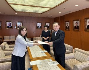 品川代表から報告書の手交を受ける長内議長（右）と村上副議長（右から2人目）