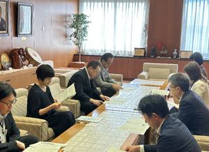 報告書の説明を受ける長内議長（左から3人目）と村上副議長（左から2人目）