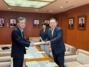 庄司代表監査委員（左）から報告書を受け取る長内議長（右）と村上副議長（右から2人目）