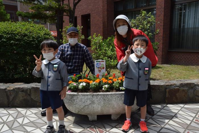 花を植えた花壇と一緒に記念写真