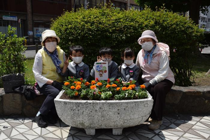 花を植えた花壇と一緒に記念写真