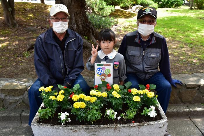 花を植えた花壇と一緒に記念写真