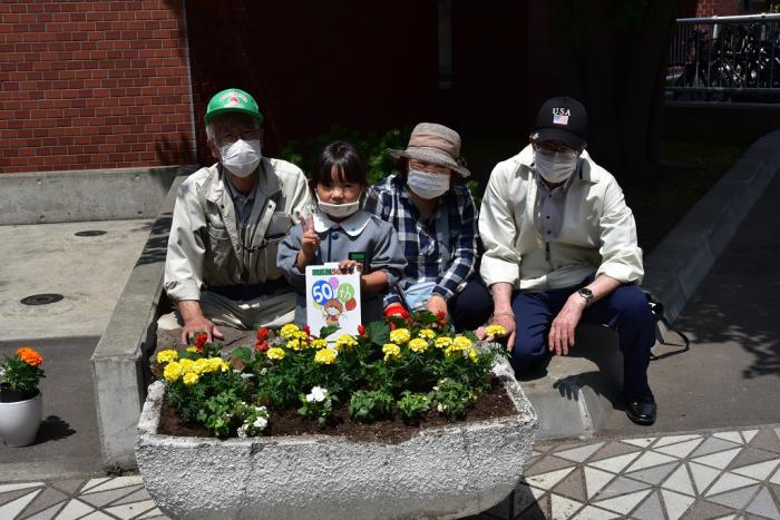 花を植えた花壇と一緒に記念写真