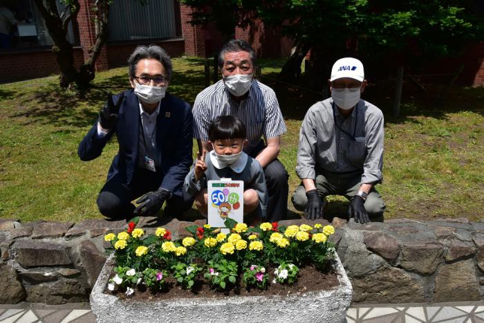 花を植えた花壇と一緒に記念写真