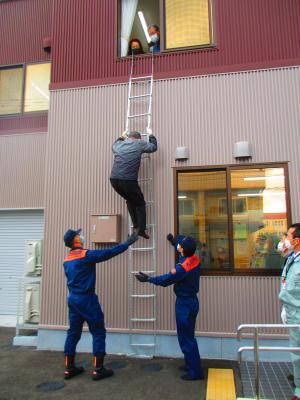 2階から避難梯子を使って避難する様子