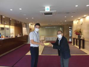 連町会長から高齢者施設長へ手渡し風景
