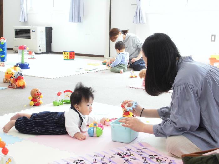 腹ばいになった乳児が気になるおもちゃをじっと見ている様子