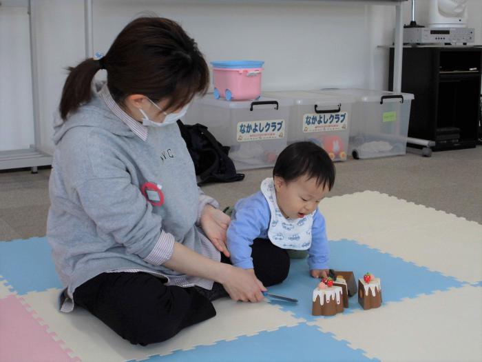 カットできるおもちゃのケーキで遊ぶ親子の様子