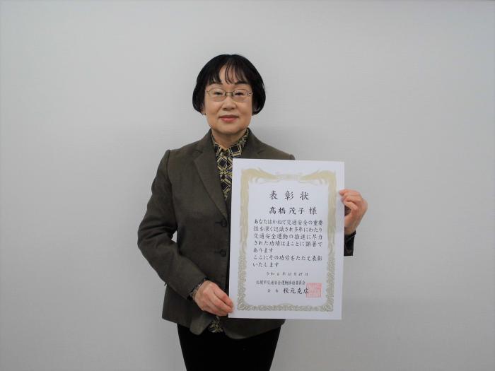 表彰状を手に微笑む受賞者の様子