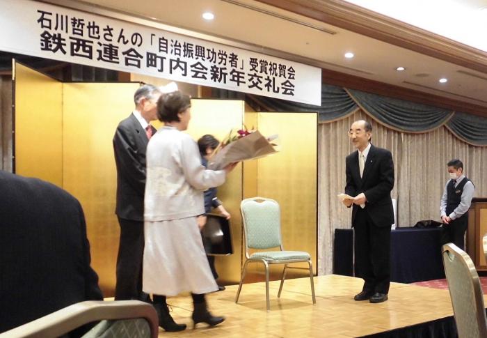 表彰を受けた石川氏が花束を受け取っている様子