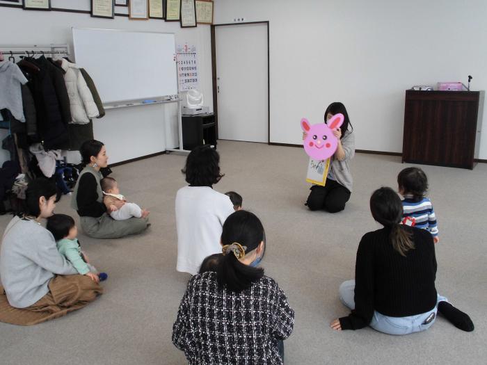 円い画用紙がうさぎの顔に変わっていくところを見ている親子たちの様子