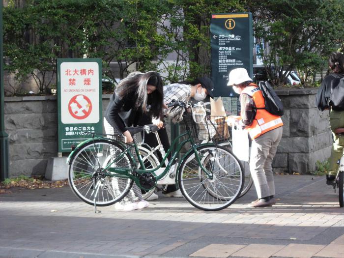 自転車に乗っている方に啓発品を渡している様子