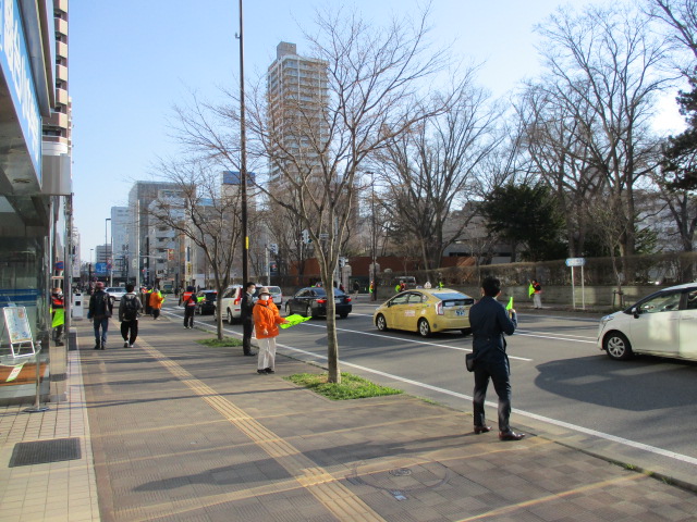 交差点で通り過ぎる自動車に安全運転を呼び掛けている様子