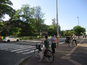 信号待ちをしている自転車に乗った方へ、お巡りさんが声掛けをしている様子