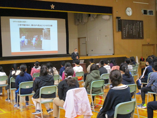 小学校体育館で「まち歩き」の事前説明を鉄西まちづくりセンター所長から受ける6年生の様子