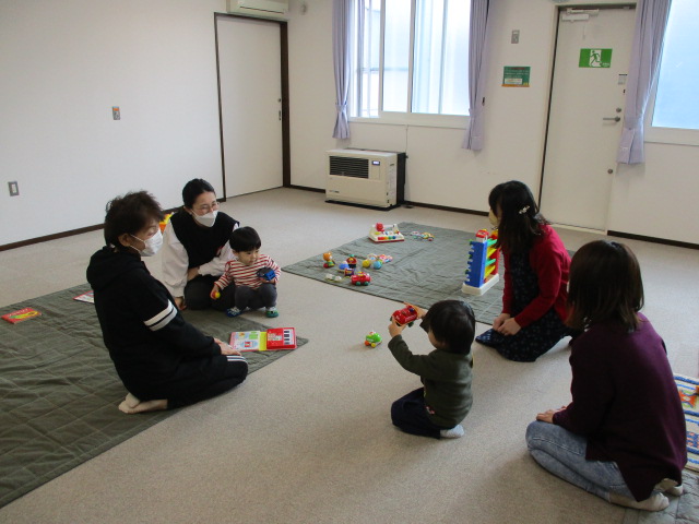 2組の親子が仲良くオモチャで遊んでいる様子