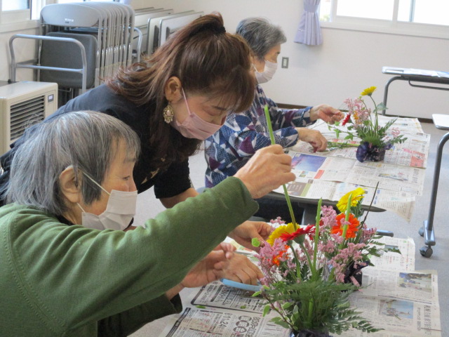 ひとつひとつ丁寧にお花を生けている女性の様子