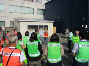 鉄西会館駐車場で、交通部長の挨拶を聞いている参加者たちの様子