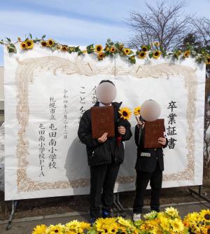 屯田南小学校の卒業式に設置したフォトスポットと記念撮影する子どもたち