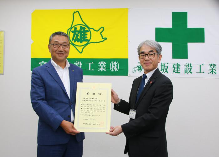 感謝状を見せる宮坂建設札幌支社長と北区長