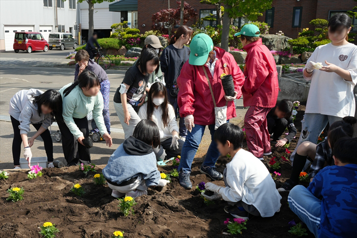 ボランティア団体の方から植え方を教わる児童