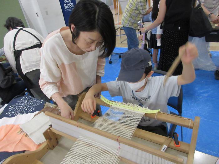 亜麻の繊維で布を織る子ども