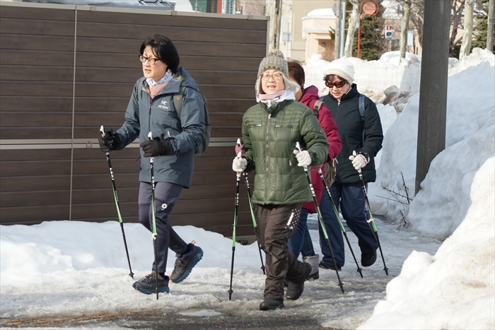 ポールを使って歩く参加者