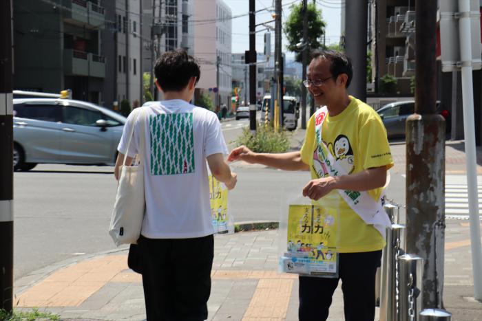 リーフレットを手渡すようす